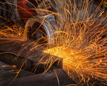 Close-up of male worker cutting metal in factory