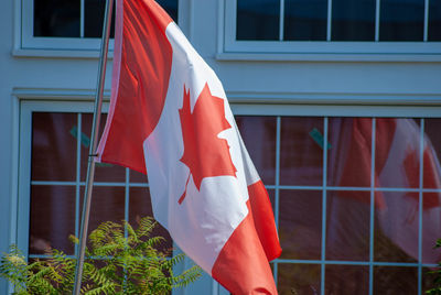Canadian flag against sky seen through window