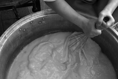 Cropped hands of person preparing food in kitchen