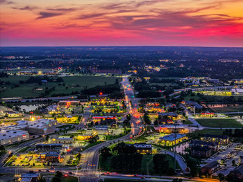 High angle view of illuminated cityscape against sky during sunset