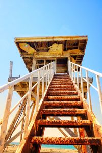 Low angle view of old abandoned lifeguard hut against clear sky