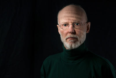 Portrait of man against black background