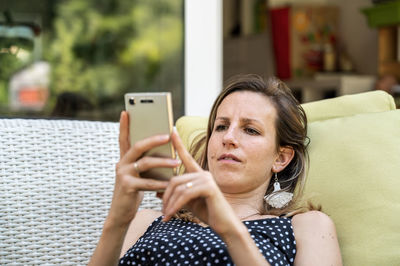 Portrait of woman using mobile phone at home