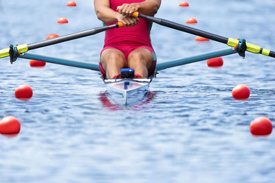 Low section of man rowing scull in river