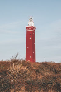 Low angle view of lighthouse on field against sky