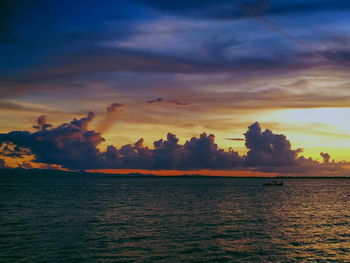 Scenic view of sea against dramatic sky during sunset