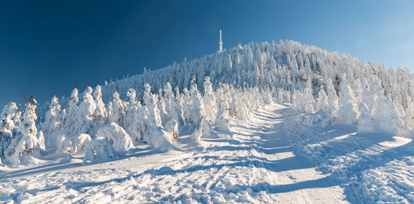 Panoramic shot of snow covered land against sky