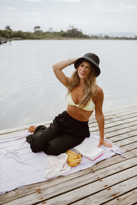 Young woman sitting on pier