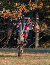 Full frame view of a motorcycle rider doing a wheelie with vivid colors