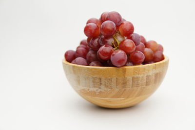 Close-up of fruits in bowl against white background