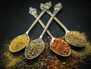 Close-up of seasoning in spoons on table