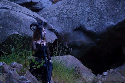 Woman in make-up sitting on rock