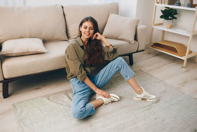 Young woman sitting on sofa at home