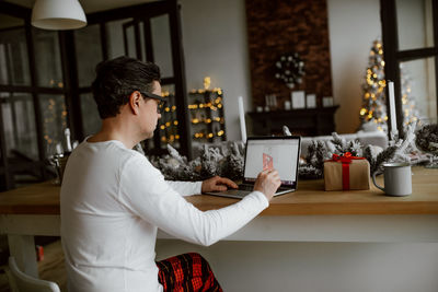 Man holding credit card using laptop at home