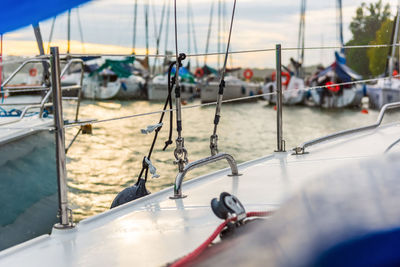 Close-up of sailboats moored in sea against sky