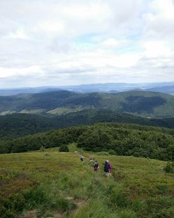 High angle view of people hiking on mountain against sky