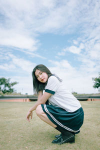 Portrait of woman crouching at park