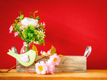 Close-up of flower vase on red table