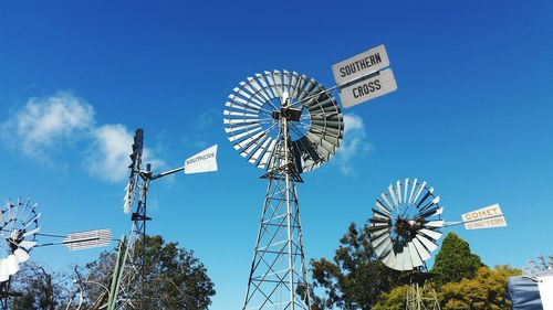 Low angle view of ferris wheel against blue sky