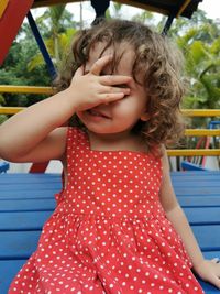 Little girl playing covering her face with her hand