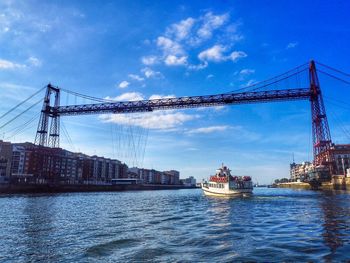 View of suspension bridge over river against sky