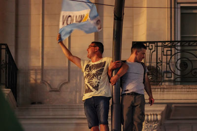 Man and woman standing against wall in city