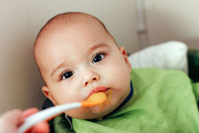 Feeding the baby. child eating by spoon baby food - vegetable puree