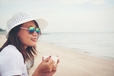 Woman having coffee at beach 