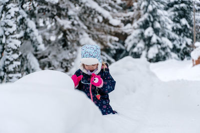 Portrait of smiling woman skiing on snow covered field