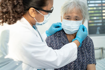 Asian doctor wearing face shield and ppe suit new normal 