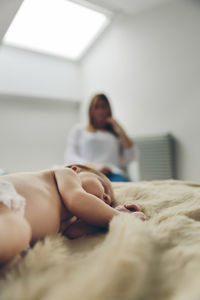 Rear view of woman lying on bed at home