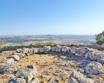 Scenic view of rocks against clear blue sky