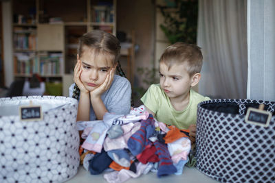 Cute sibling looking at dirty clothes