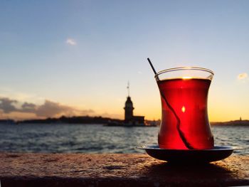 Turkish tea againstsra and sky at sunset. maiden tower on sea in istanbul, turkey. landmarks. travel