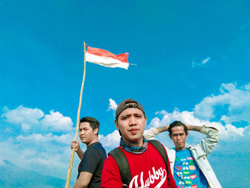 Low angle view of young man standing against sky