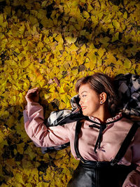 Young woman with umbrella on leaves during autumn