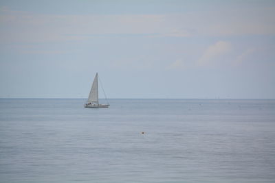 Sailboat sailing on sea against sky