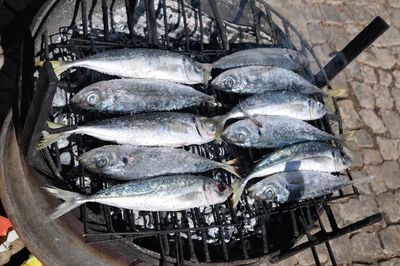High angle view of fishes cooking on barbecue grill