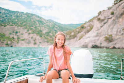 Portrait of woman sitting on boat against mountains