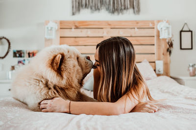 Midsection of woman lying on bed at home