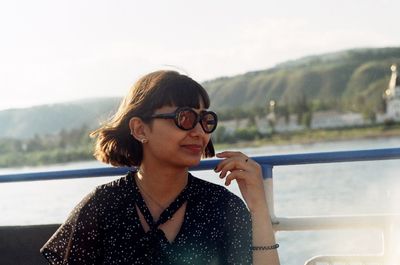 Woman wearing sunglasses on boat in lake
