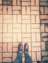 Low section of man standing on cobblestone