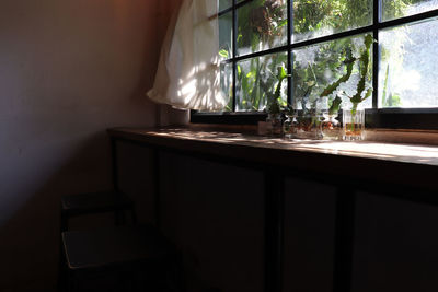 Some glass of drinking water in front of the clear glass window with white fabric curtain