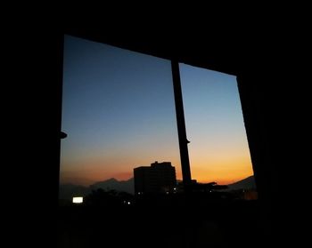 Silhouette buildings against sky during sunset