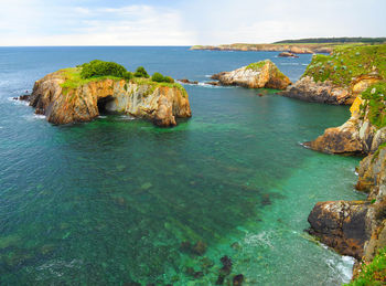 Scenic view of rocks in sea against sky