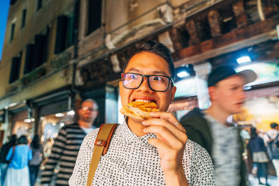 Close-up portrait of man eating in city