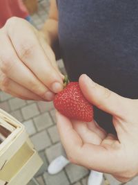 Midsection of man holding strawberry