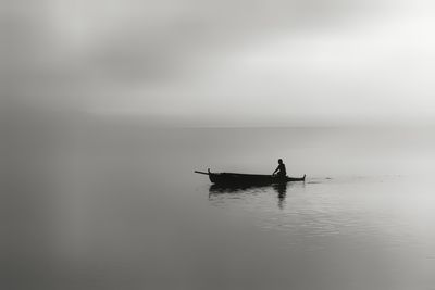 Silhouette of person in a boat in sea