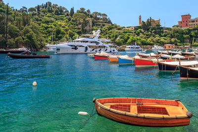 Boats moored in sea against blue sky