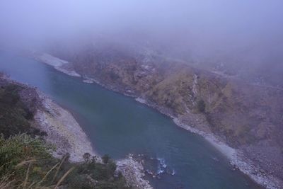 High angle view of river amidst mountains against sky